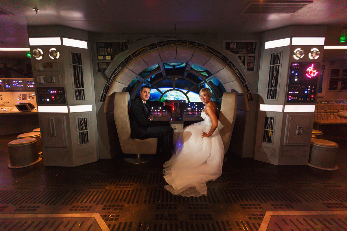 Couple sitting in captain seats in cockpit of the Millennium Flacon on Disney Dream 