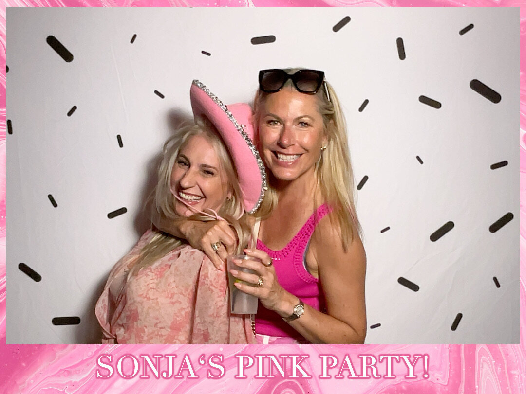 two women in pink pose in photo booth at themed 50th birthday party in christchurch