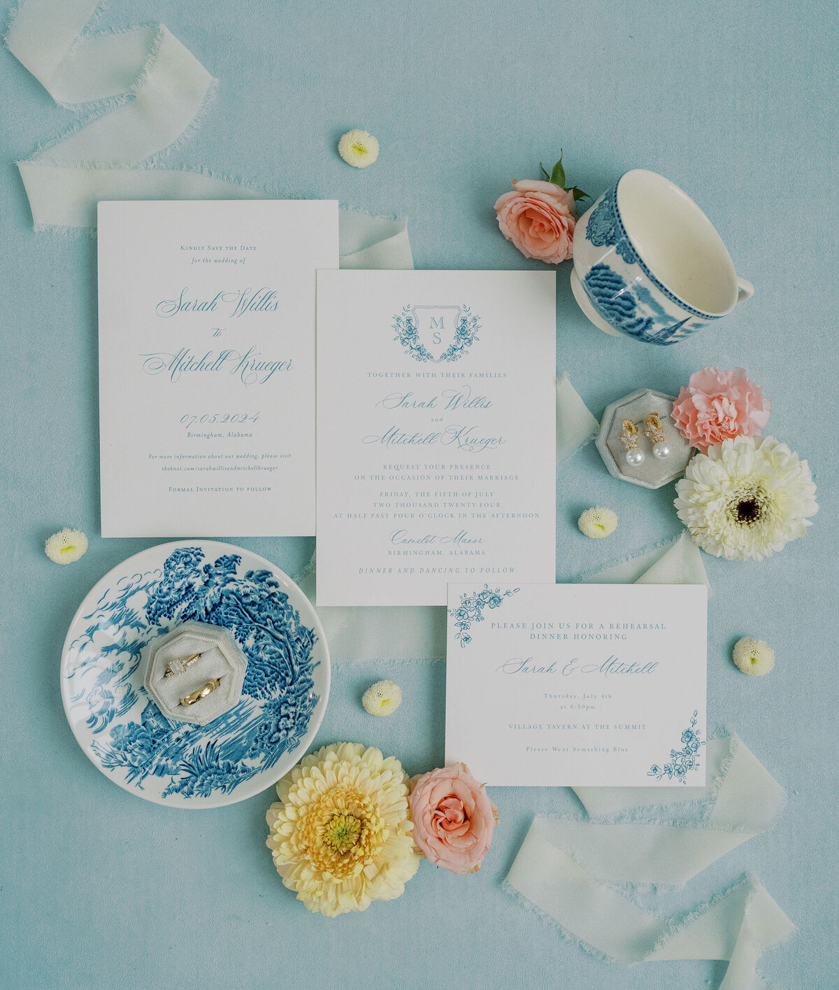 a flat lay with blue, white, yellow, and pink wedding details