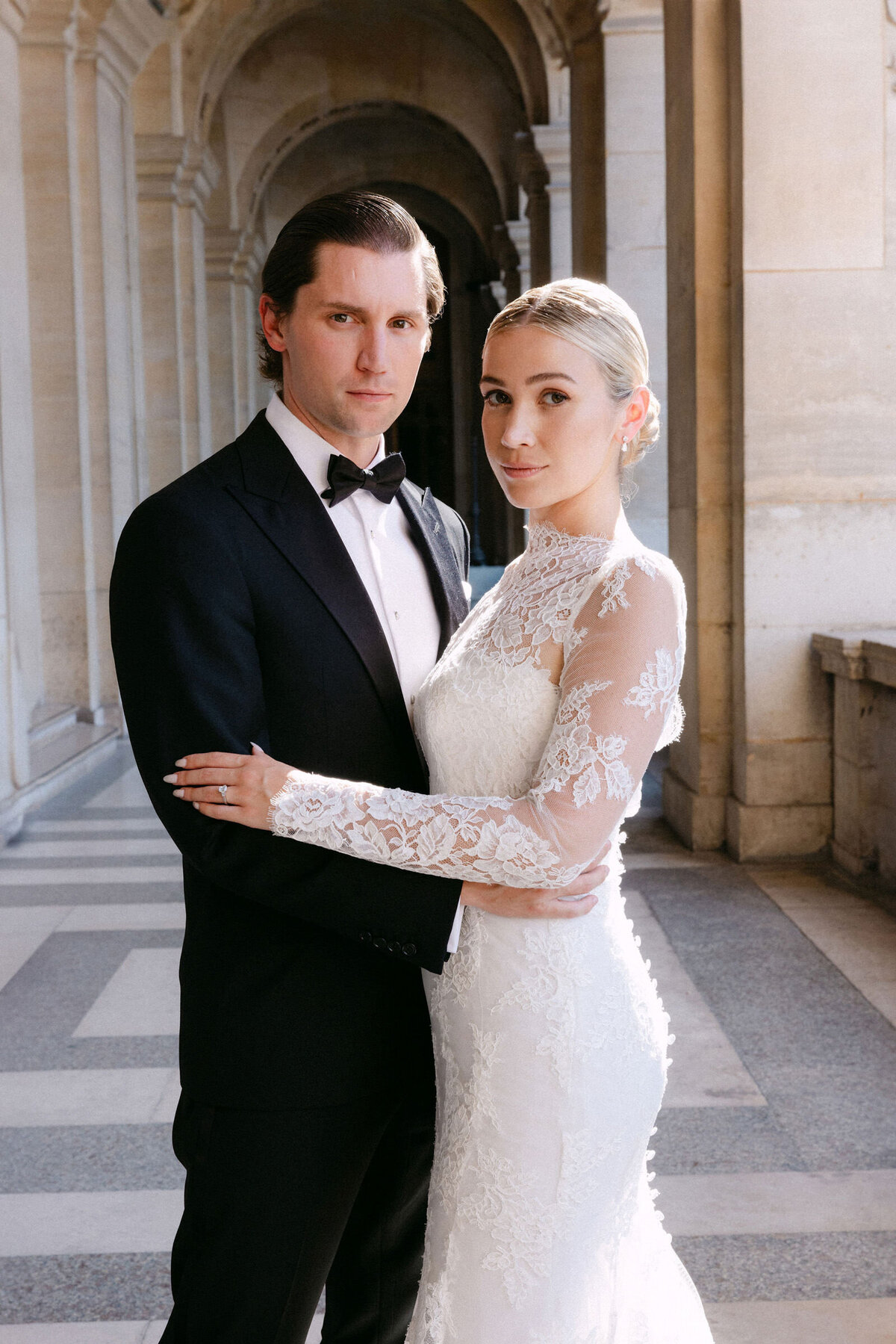 Formal portrait of the couple outside Louvre Museum.
