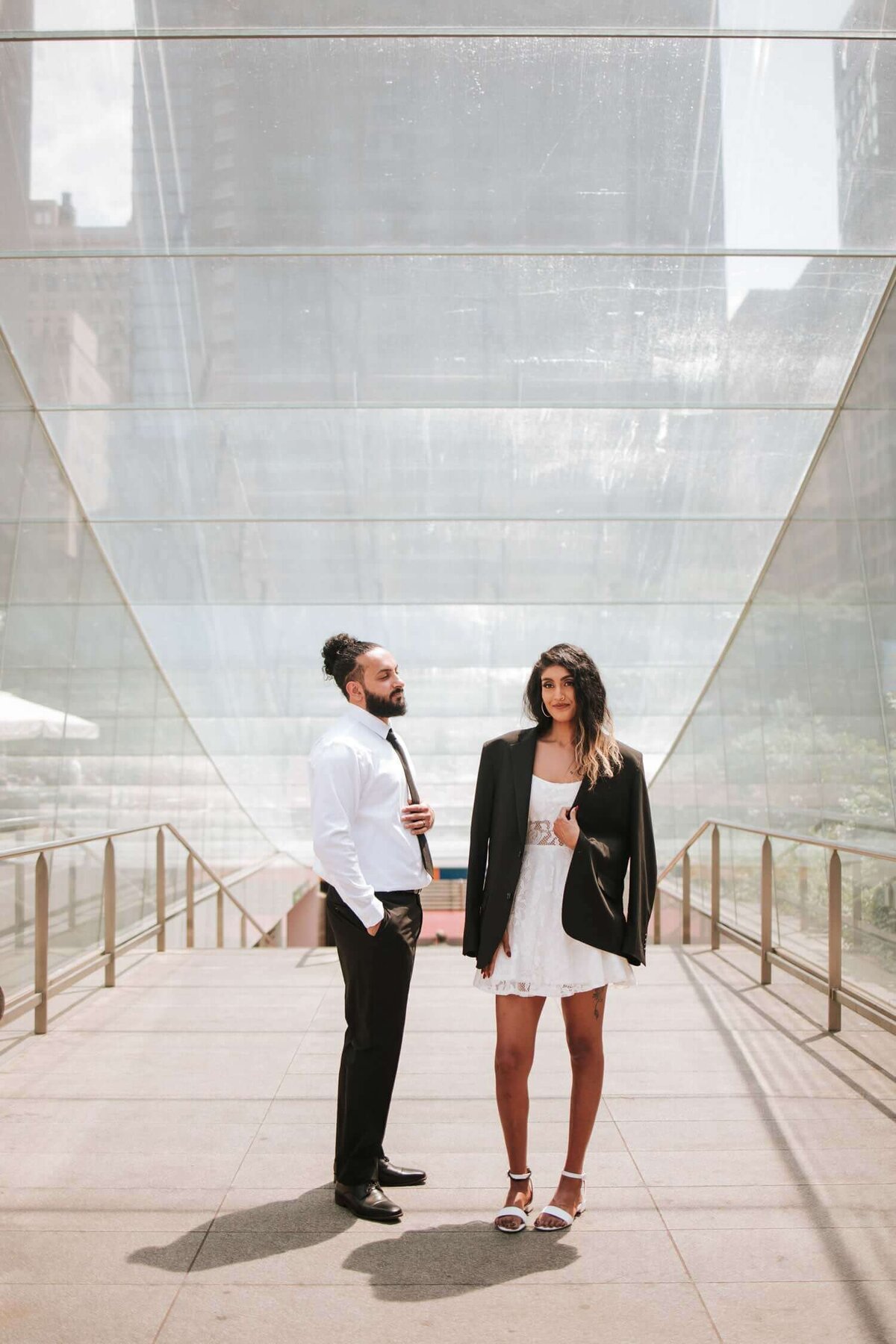 South Asian couple standing side by side on a bridge in Philadelphia during an engagement session.