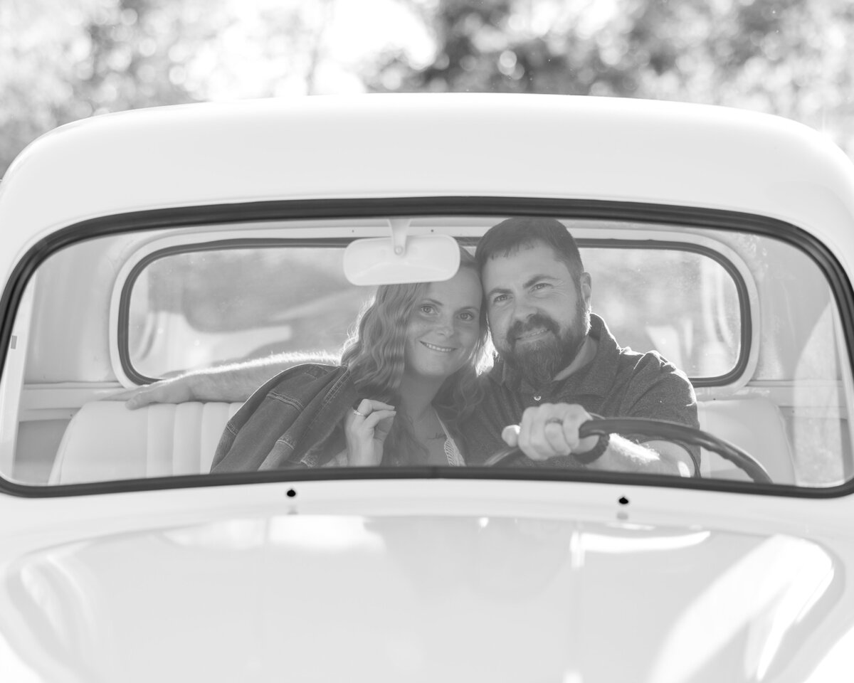 Couple sitting in the front of a white truck and looking through the window for North East, PA, couple’s portraits.