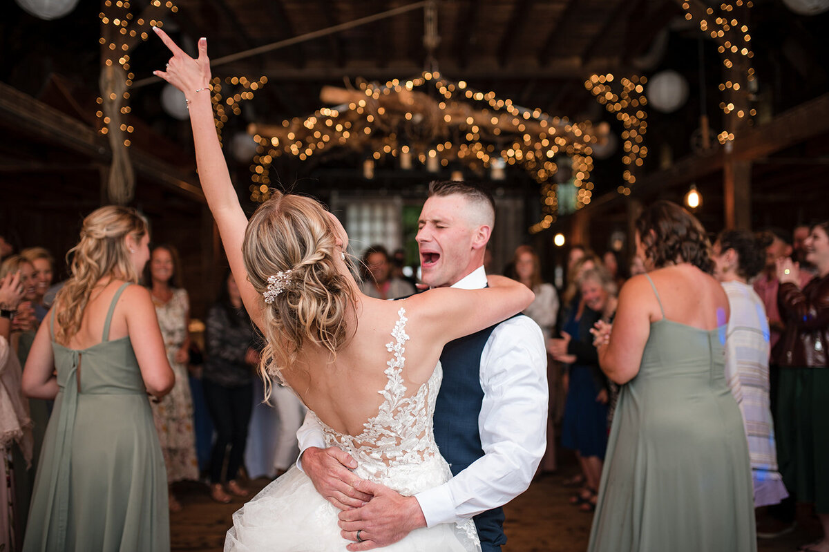bride and groom laugh and smile during their first dance at their barn wedding venue in ct