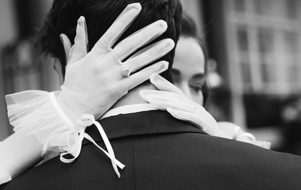 A black and white wedding photo of the bride and groom in front of the Goring Hotel in London