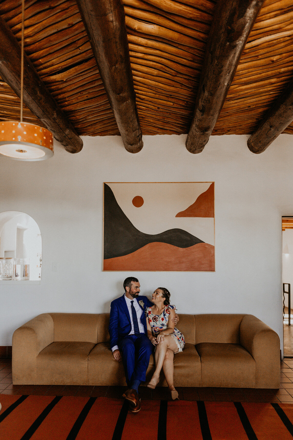bride and groom siting on a retro couch at El Rey Court in Santa Fe