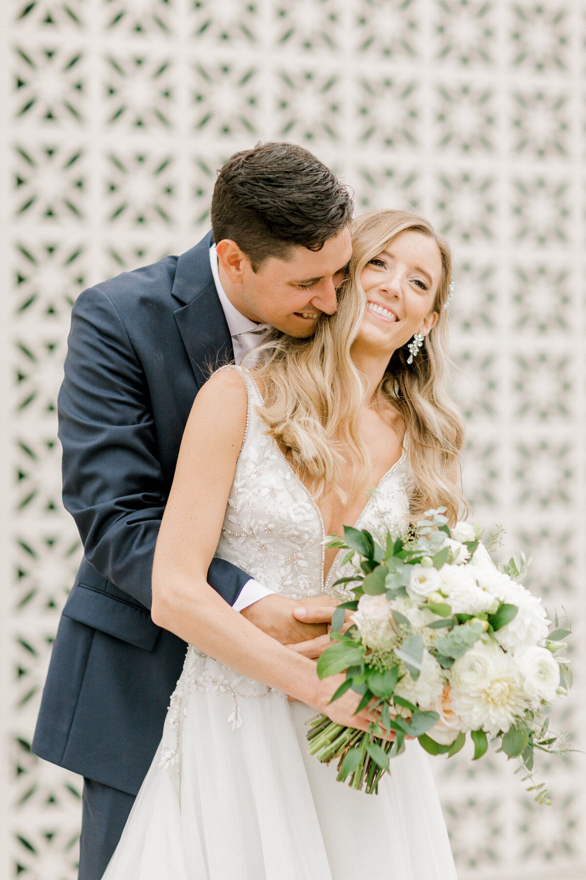 groom hugging bride from behind and laughing