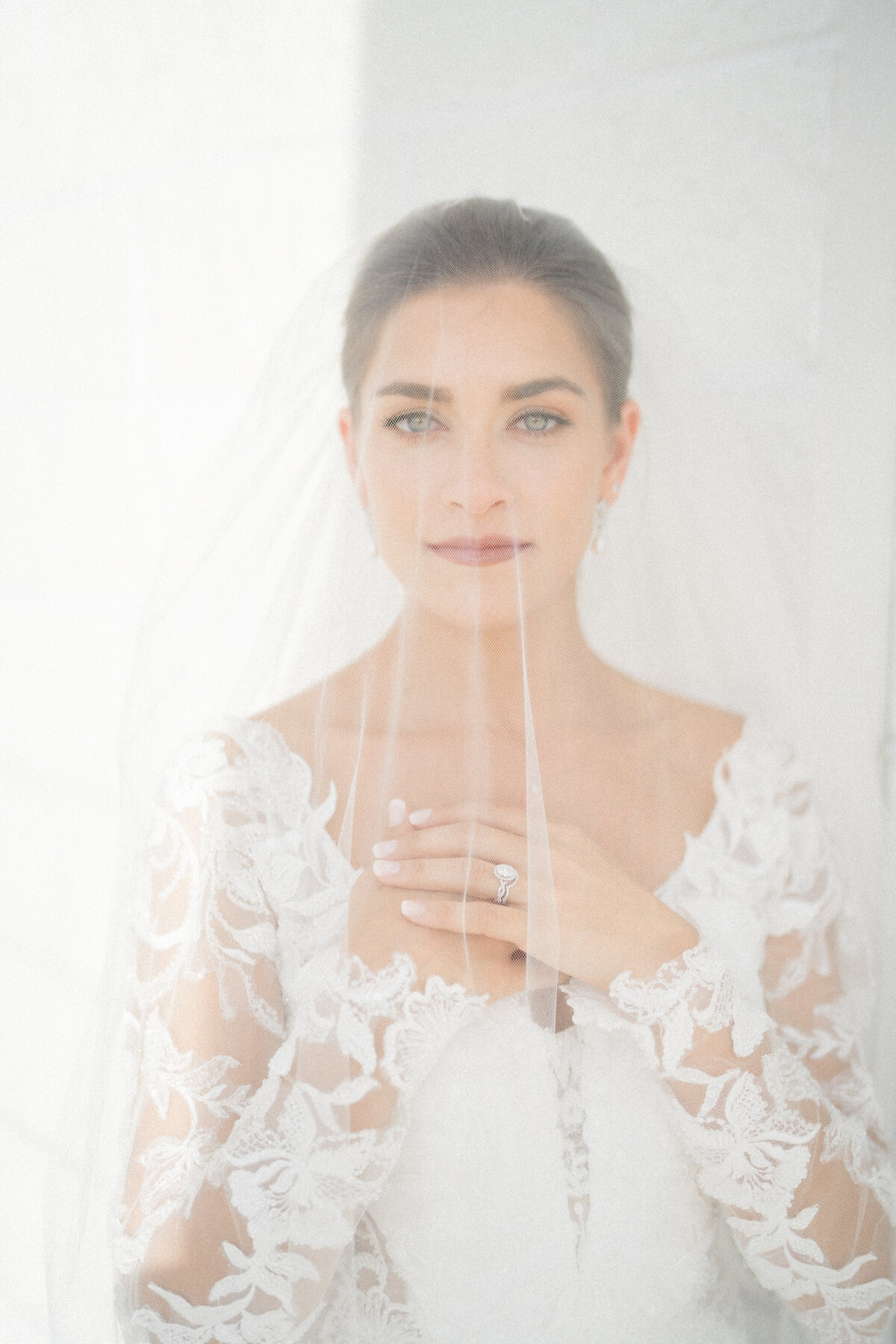  Bride wearing a delicate veil, capturing a timeless and elegant wedding moment with soft, romantic details