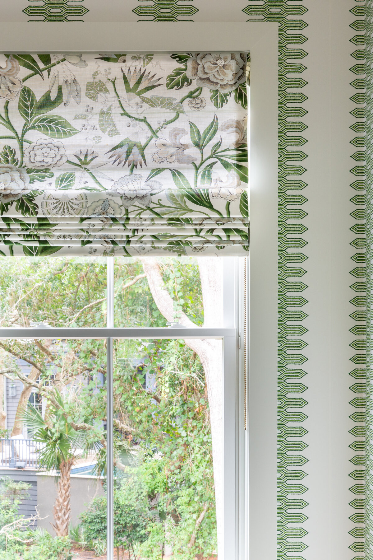Charming window seat in Kiawah Island, SC, with patterned Roman shades and soft textures.