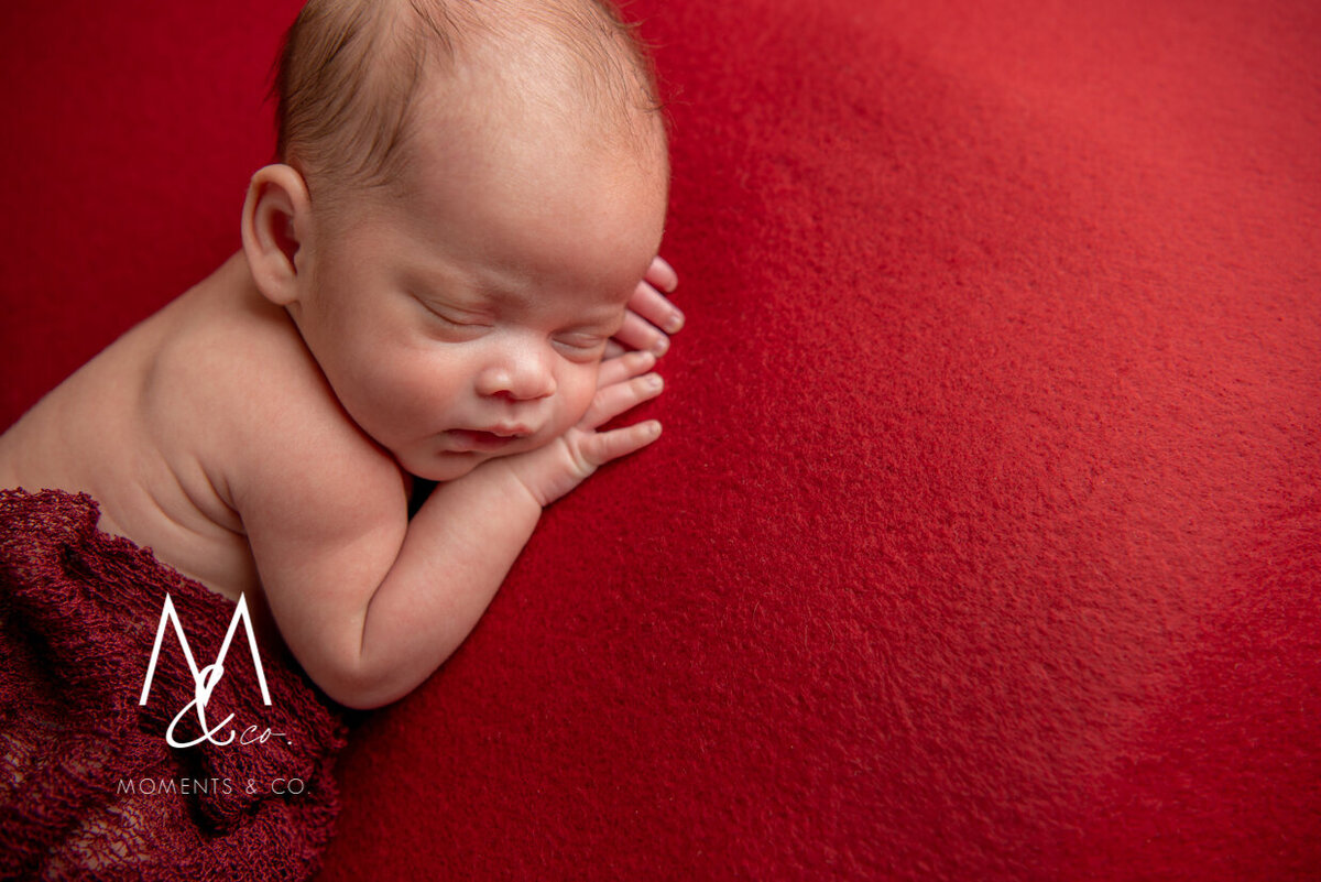 Newborn-on-red-blanket-with-red-wrap-photo-1