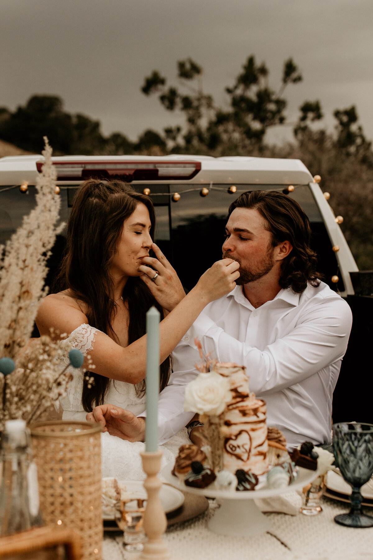 newlyweds  feeding each other cake in their truck bed in New Mexico