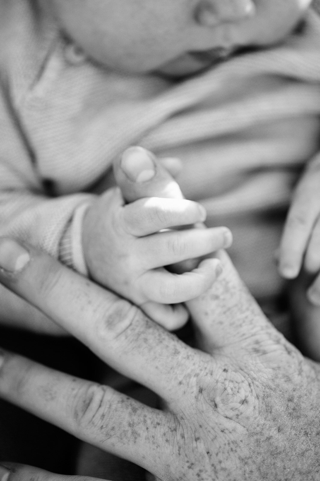 Baby gripping parent's finger tightly.