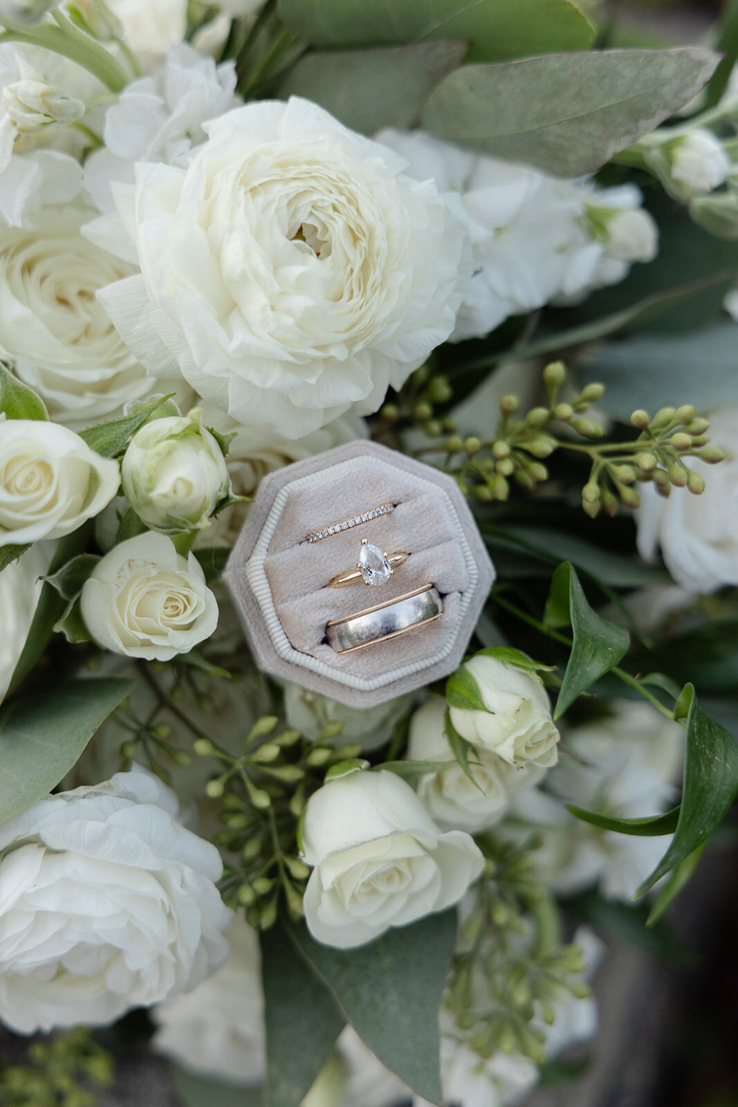 worcester wedding photographer documents a detail photo of classic green and white florals with a teardrop engagement ring at The White Room wedding venue in Worcester, MA (arianna lyn photography, Worcester wedding photographer)
