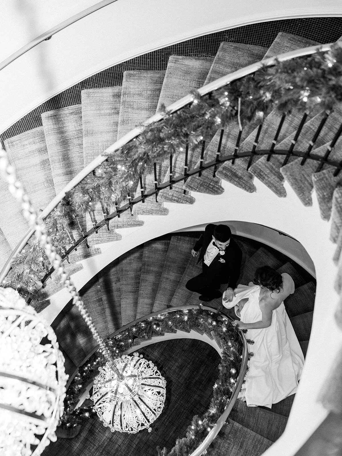 Couple walks down the stairs at the spiral staircase at Hotel Washington 