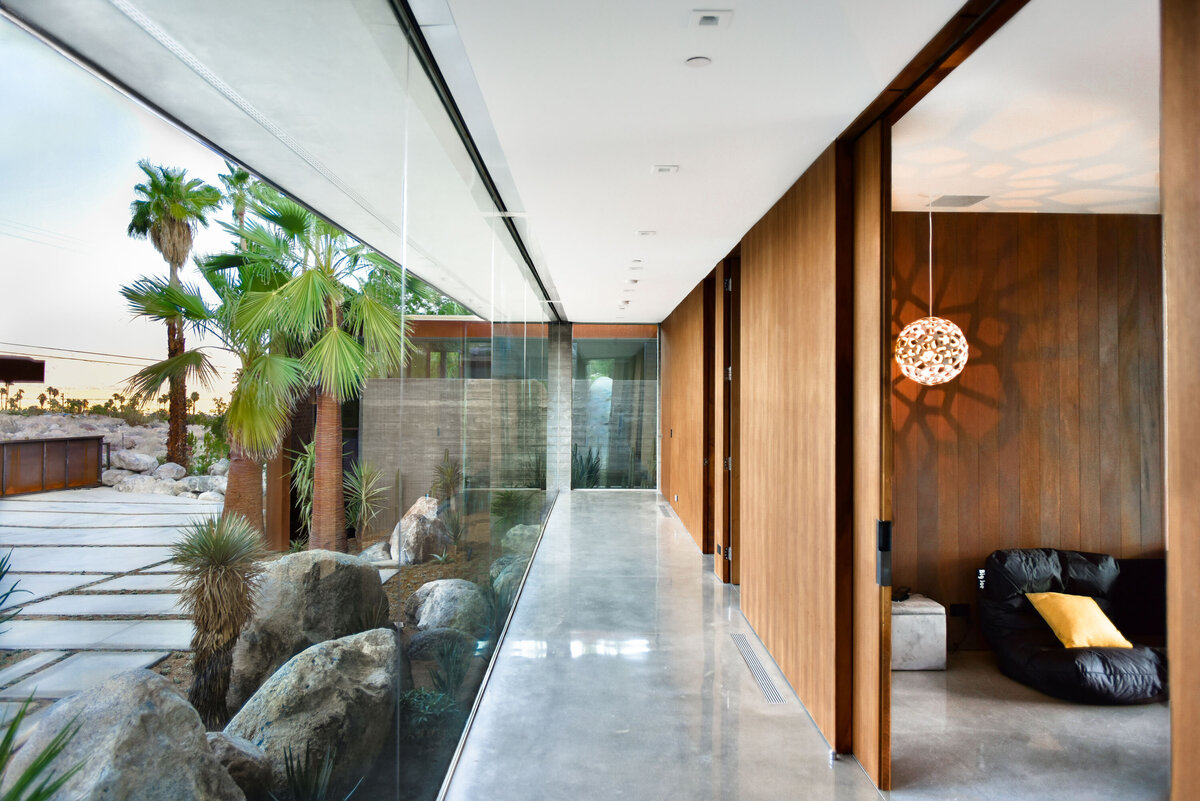Glass corridor at modern palm springs home designed by los angeles architect