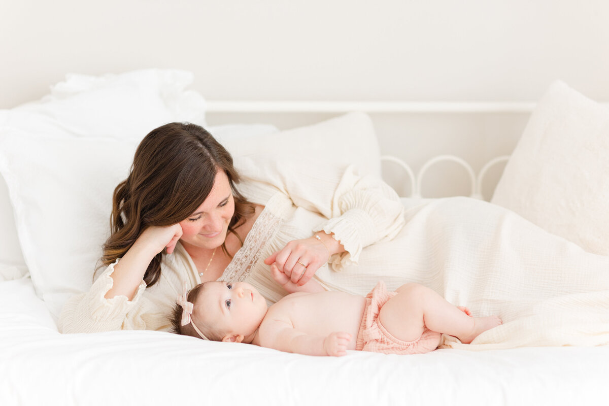 a northern virginia family photography photo of a mama snuggling with her daughter on a white bed