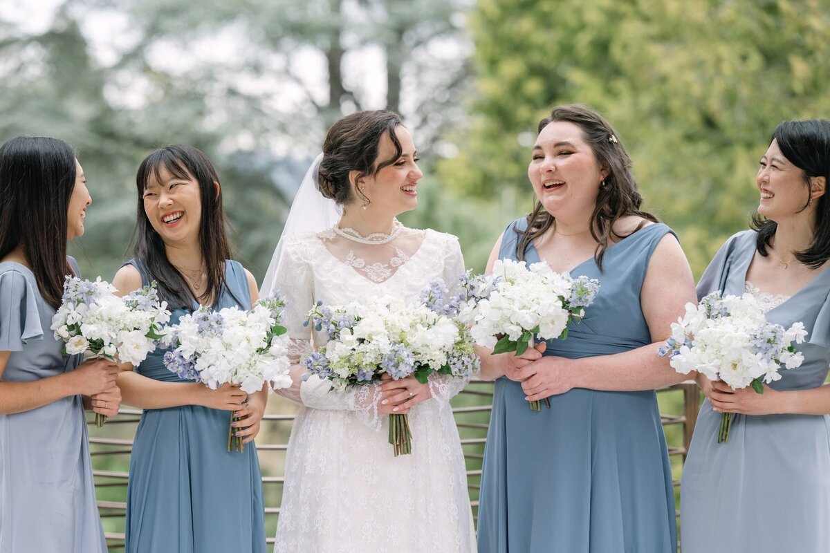 blue bridesmaid dresses with bride at park 