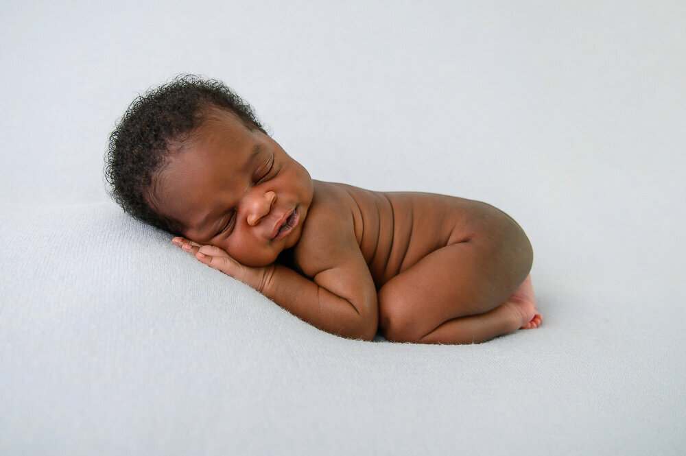 black newborn baby boy on a blue background