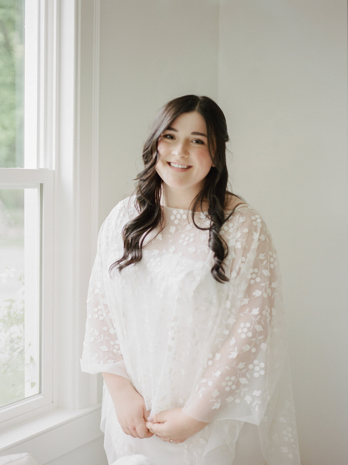 bride with dark hair and bridal cape in white room, west Michigan wedding venue