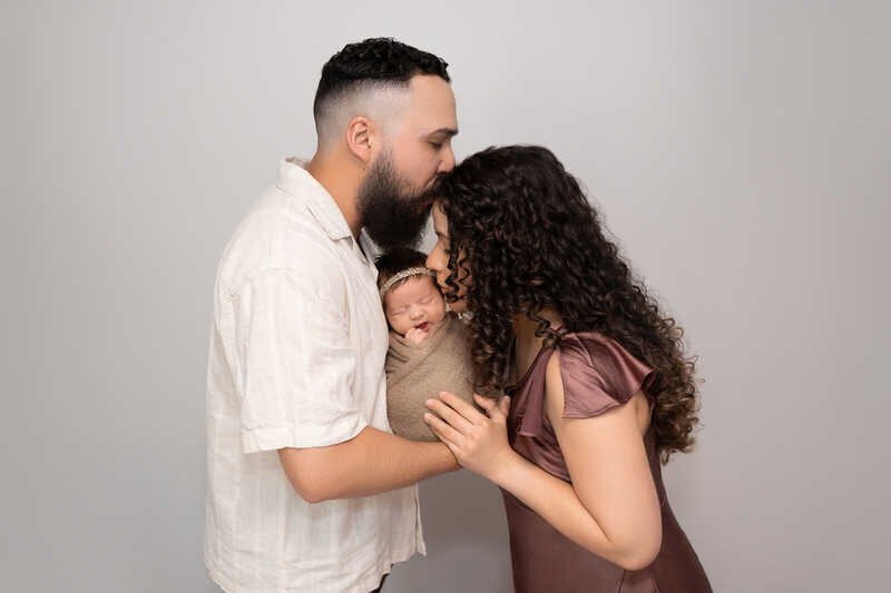 Couple embracing during Houston family photography session in soft studio lighting.