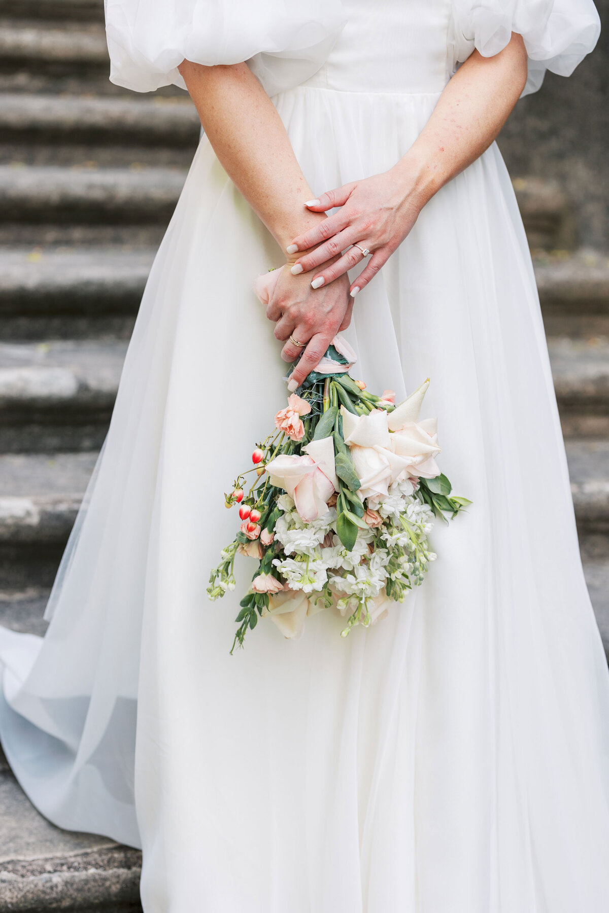 detail of bride's bouquet against her dress