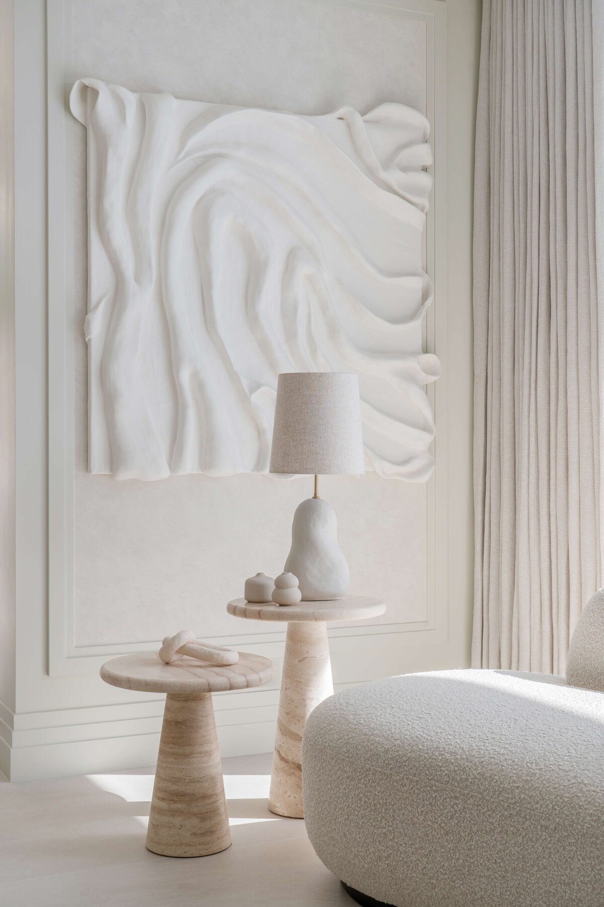 White will with dramatic textured white art piece adding drama intrigue to the space.