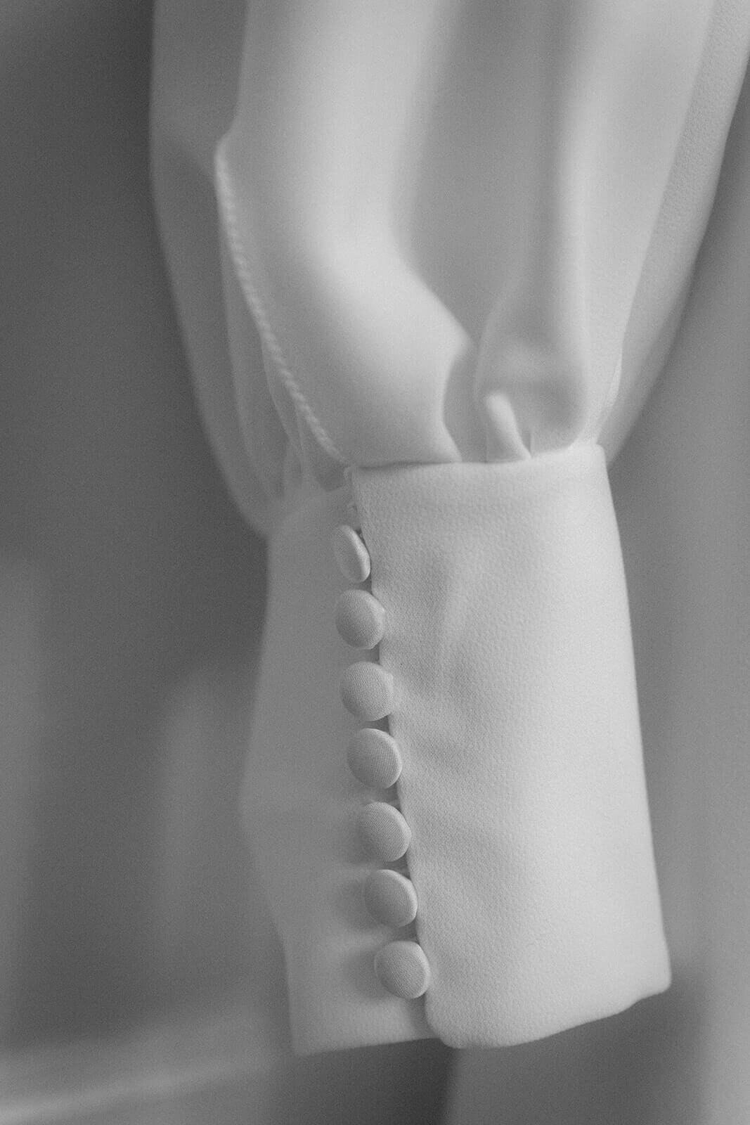 The sleeve of a wedding dress and 6 buttons at an Edinburgh wedding venue.
