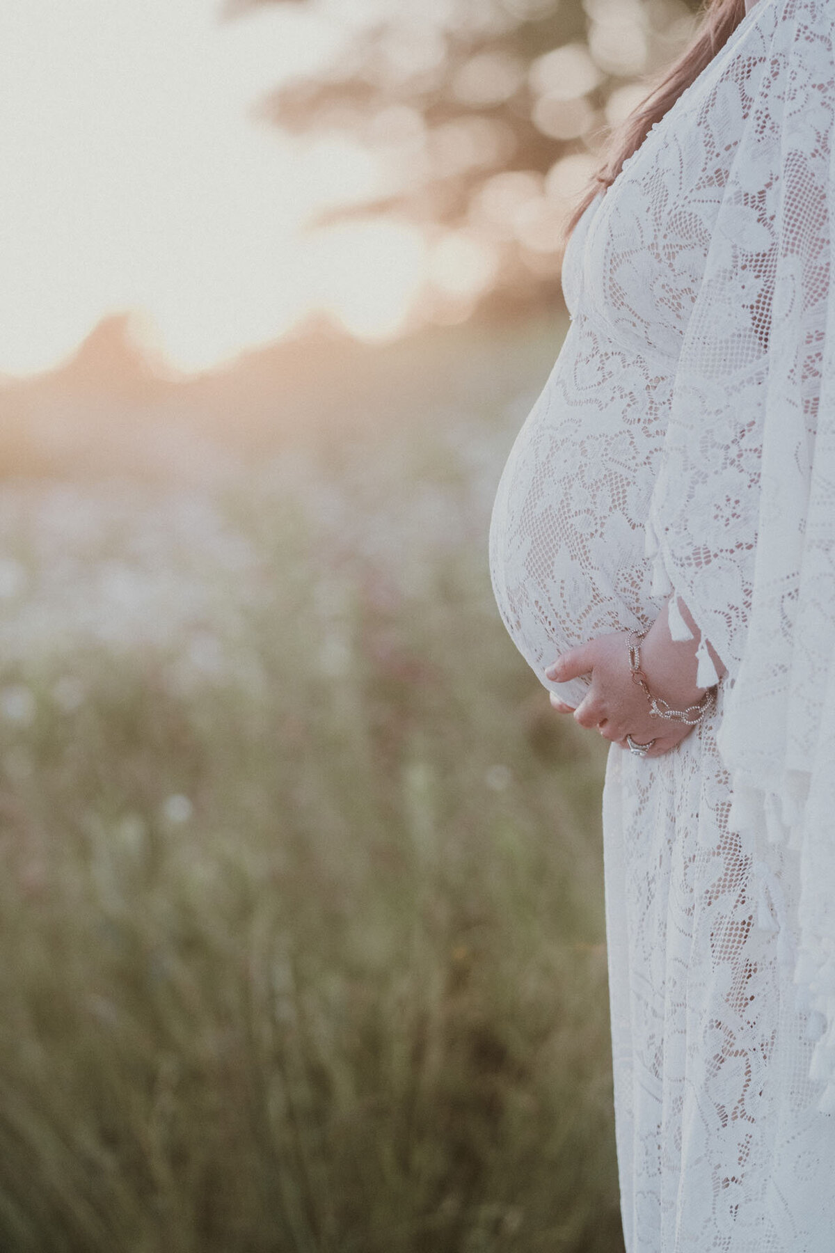 close up of expecting mom in lacy white dress