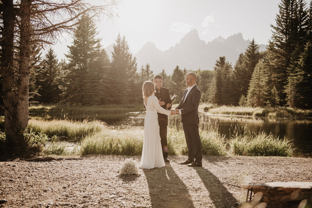 Teton elopement bride and groom are married at a lake with bright white light