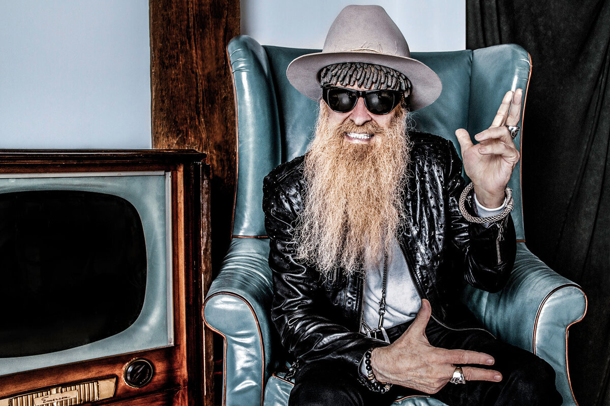Billy F Gibbons portrait sitting in blue chair beside old television