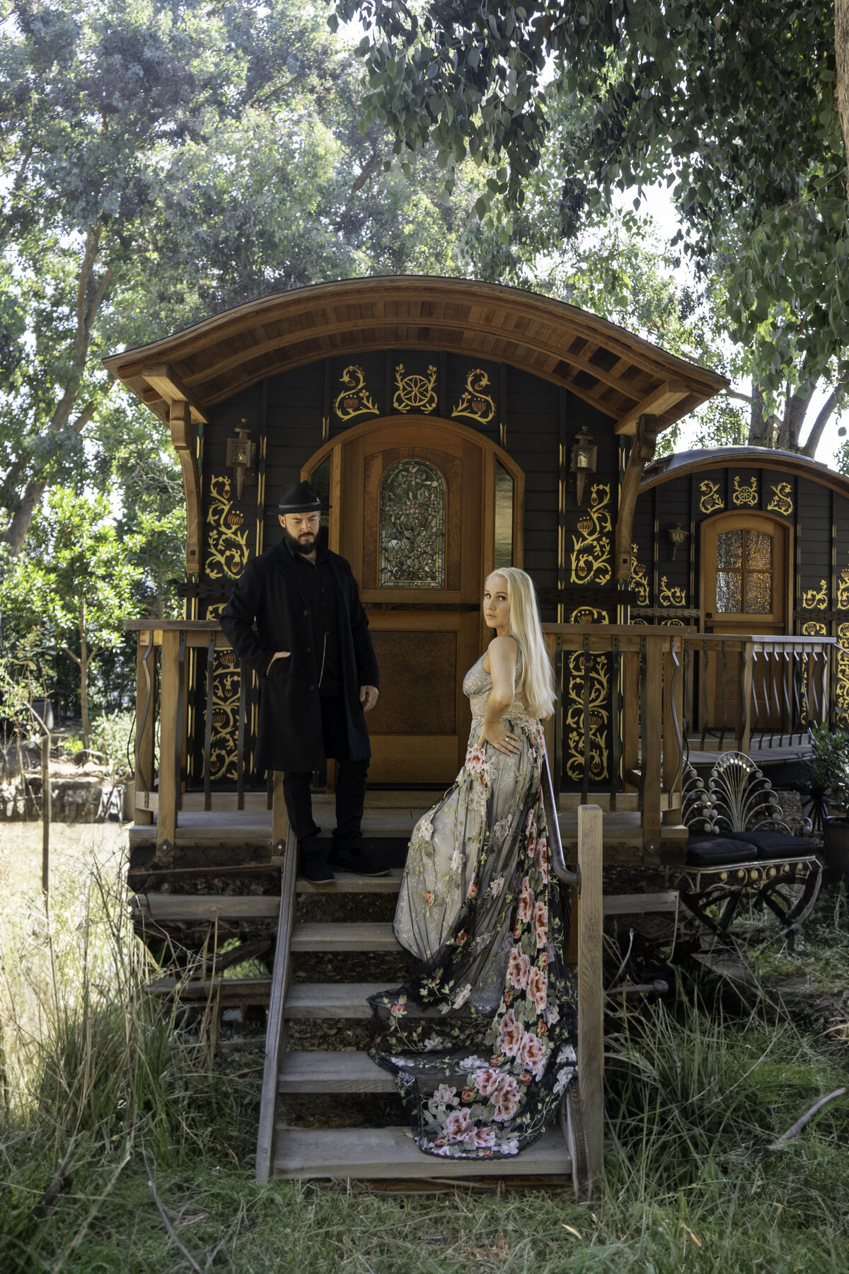 Engaged couple in the mountains of Malibu outside a gypsy caravan with Peaky Blinder inspired attire and a colorful lace Claire Pettibone gown