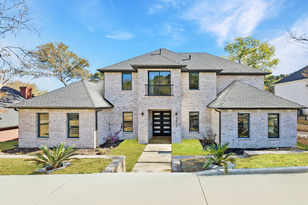 Stunning new construction luxury home in a peaceful, established neighborhood featuring light brick exterior, modern black-framed windows, and a grand double-door entry. This two-story residence offers a timeless design with clean rooflines, landscaped front walkway, and mature trees surrounding the property. Ideal for buyers seeking a sophisticated home with curb appeal near top North Texas amenities.