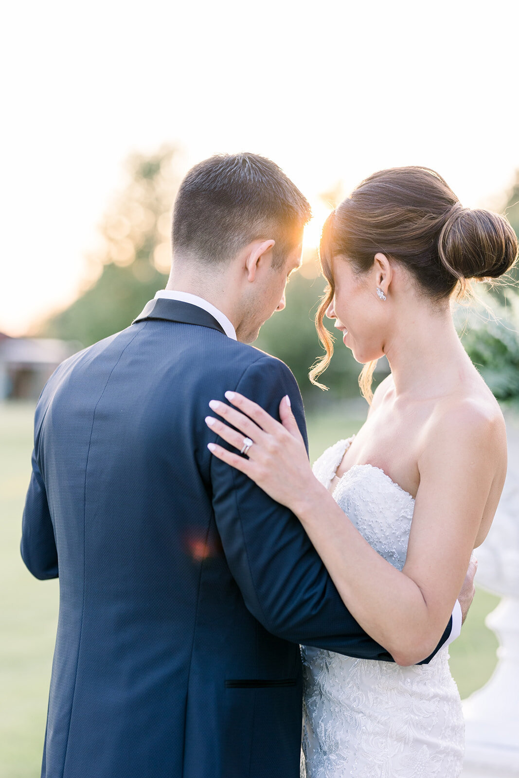 NEwlyweds watch the sunset while hugging on a patio