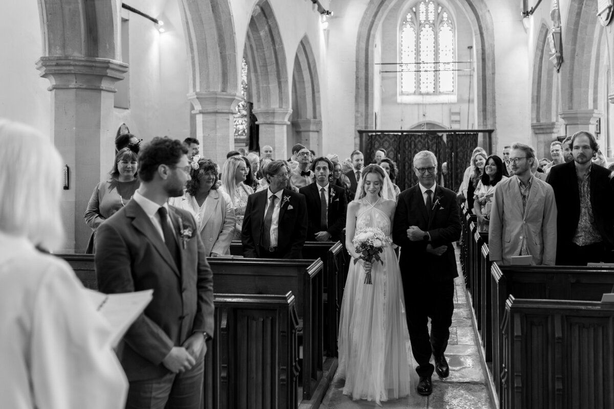 The bride walks down the aisle at her church wedding ceremony