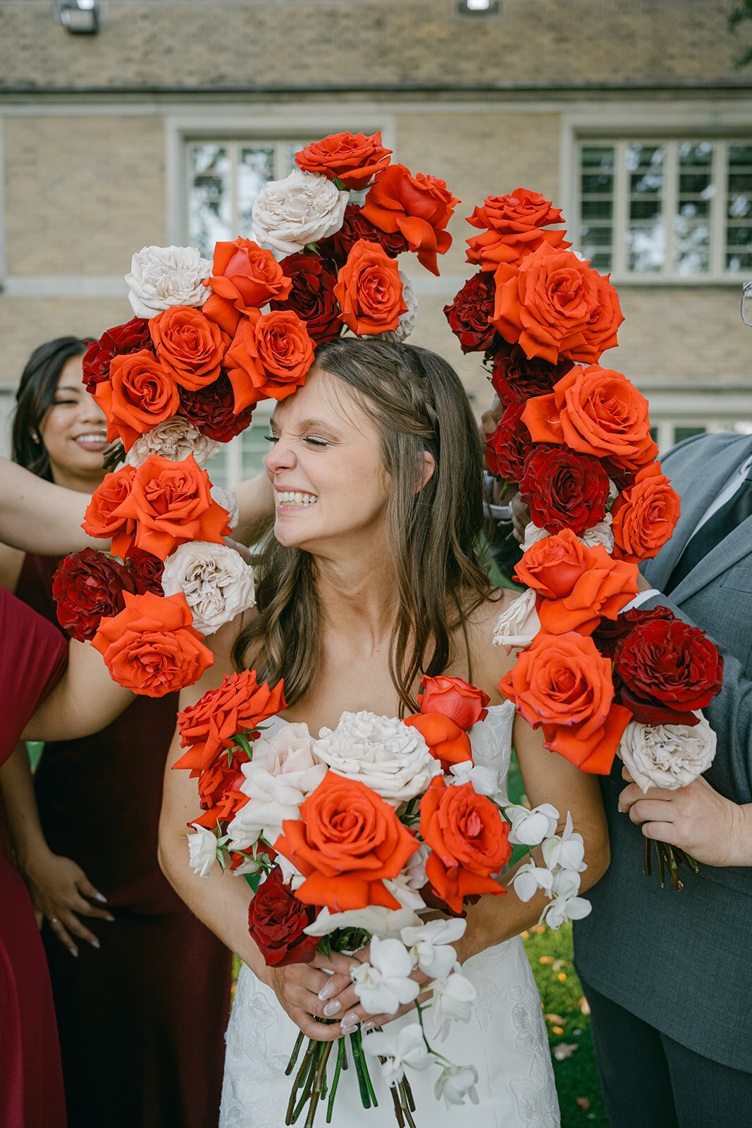 Candid bridal moment framed by dramatic red floral bouquets at San Antonio luxury wedding