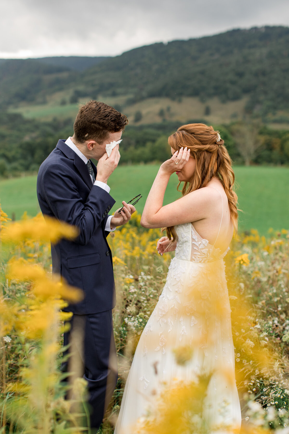Wedding photo in Boone, NC of a bride & groom wiping their eyes emotionally on their wedding day