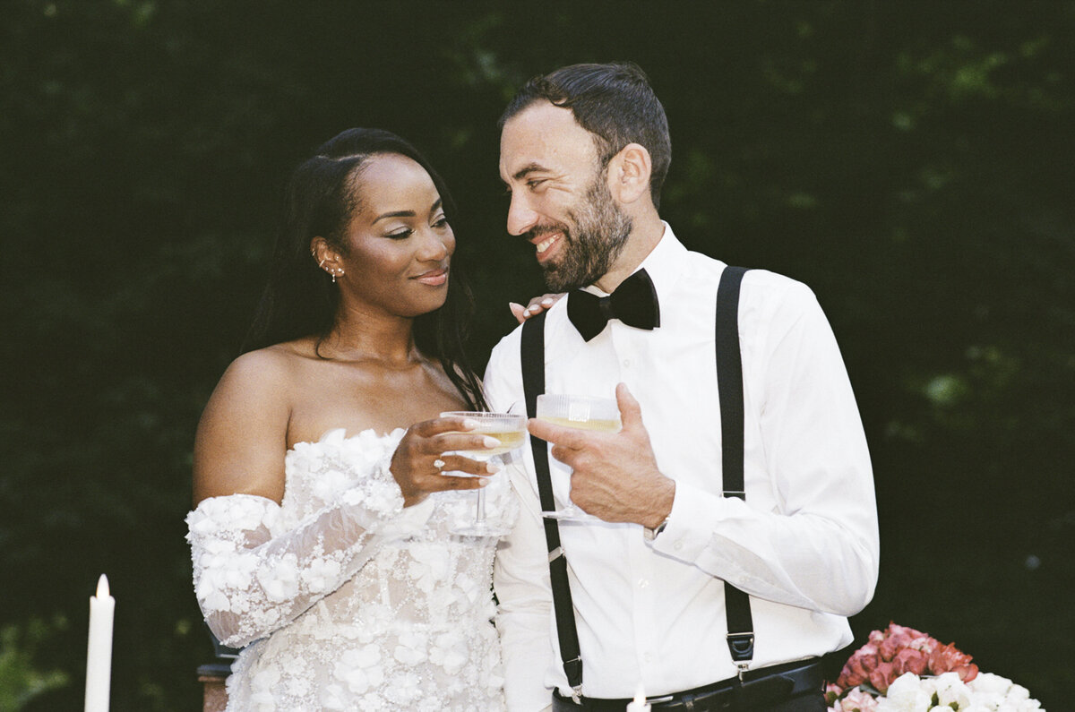 Backyard elopement photo in the Hudson Valley of bride and groom toasting shot on 35mm film