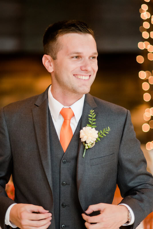 groom posing for a wedding picture in the round room at the Hyeholde