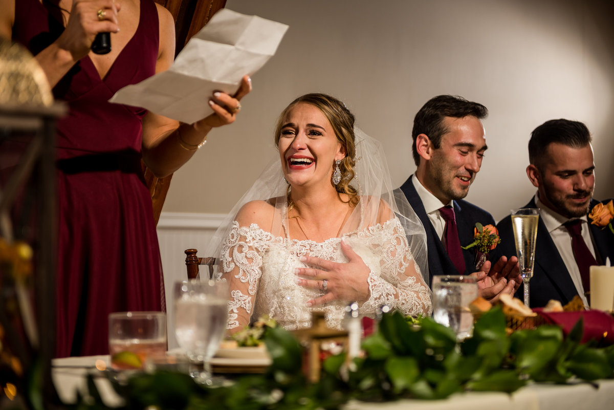 bride reacting to speech by her bridesmaid