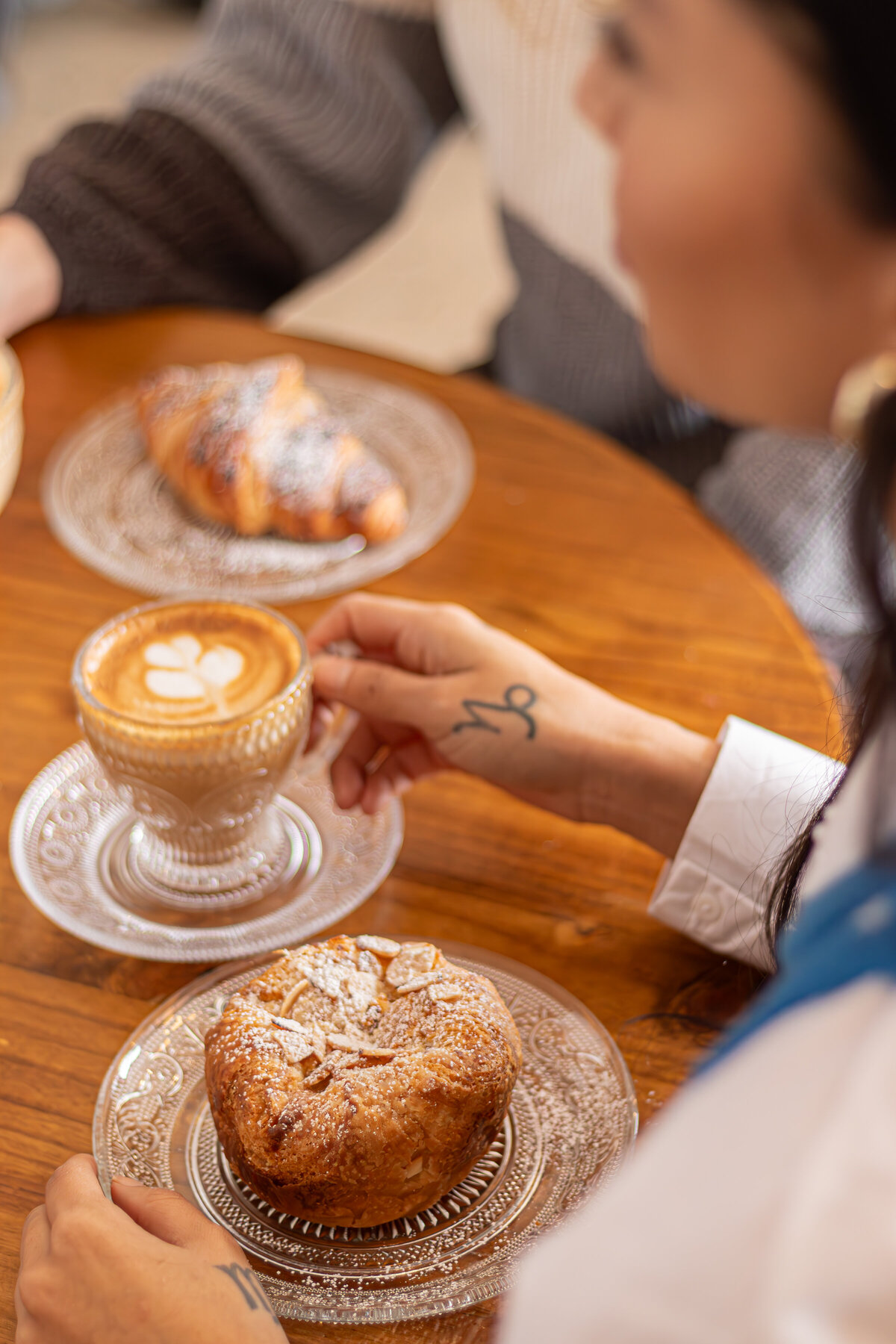 a woman's hand reaching to grab a cappucino
