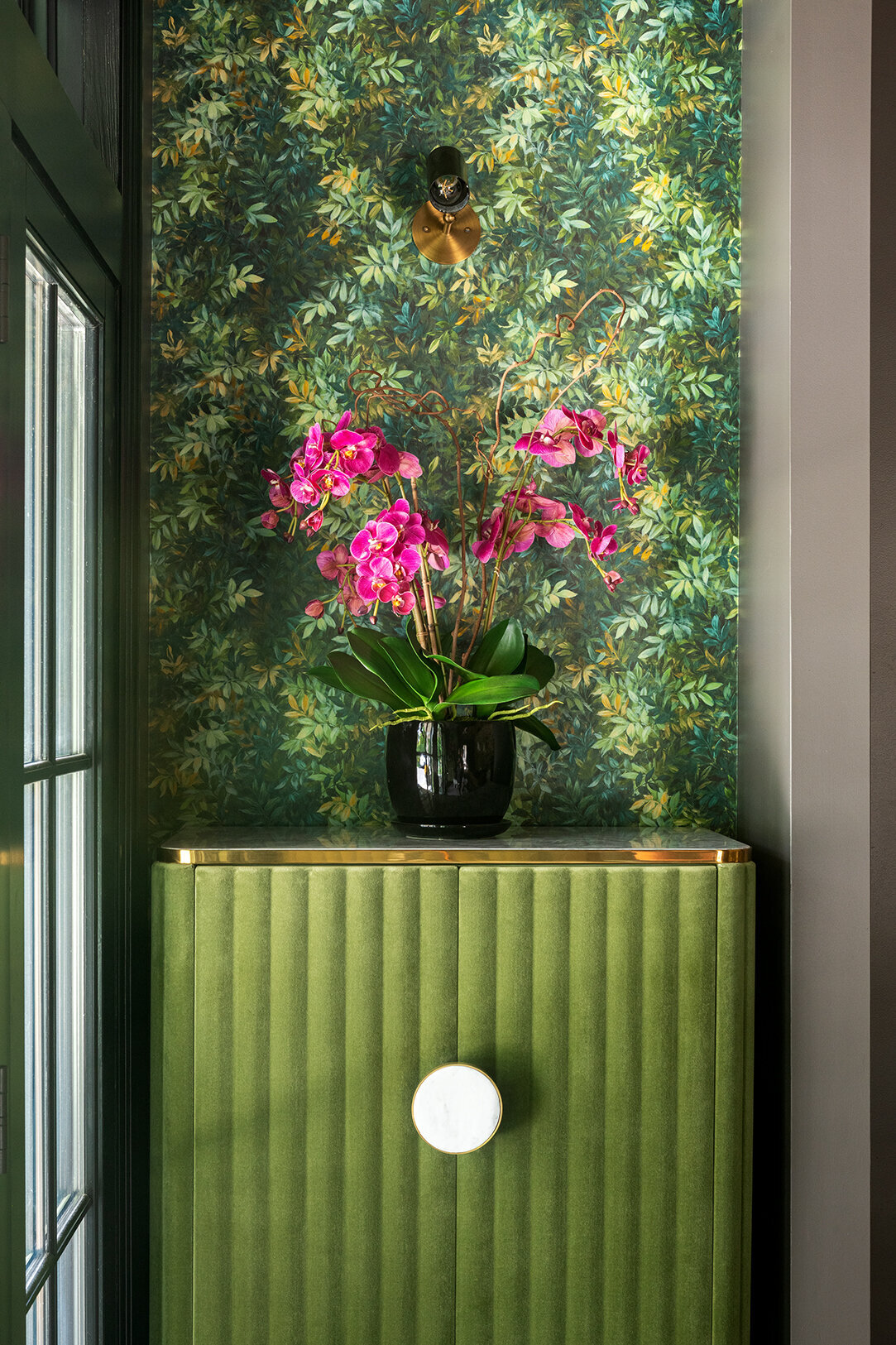 green and gold accent storage cabinet with nature patterned wall