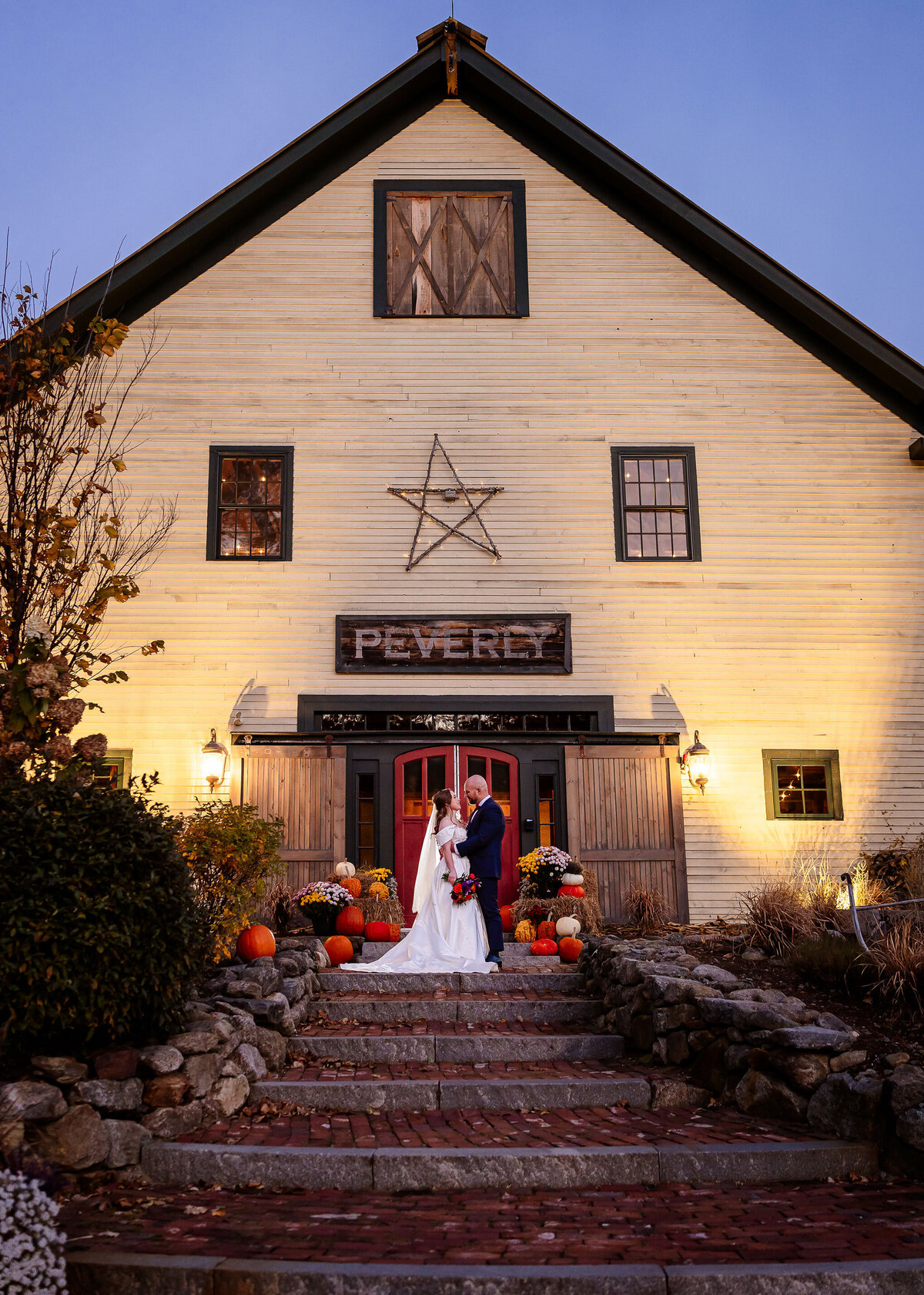 bride and groom outside the iconic red doors of the Barn on the Pemi