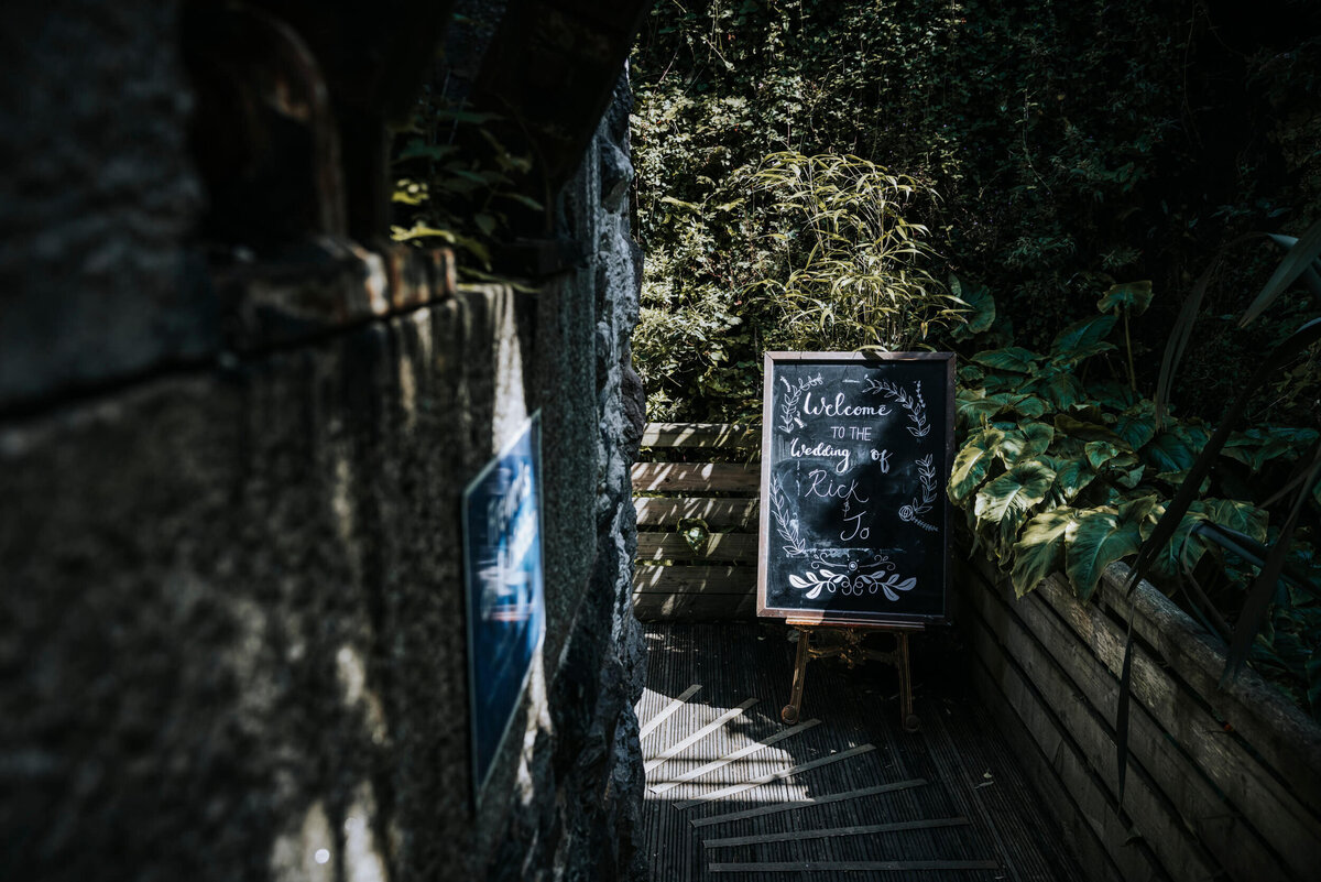 A chalkboard sign sitting on the side of a long path