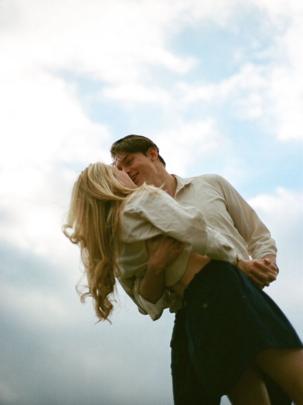 couple shares kiss against alabama sky by huntsville photographers in downtown