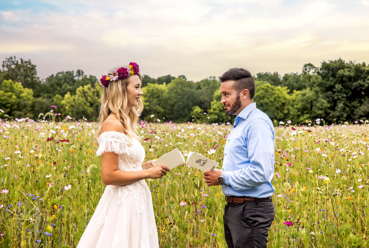 Bride and groom exchanging vows in a wildflower field with colorful blooms