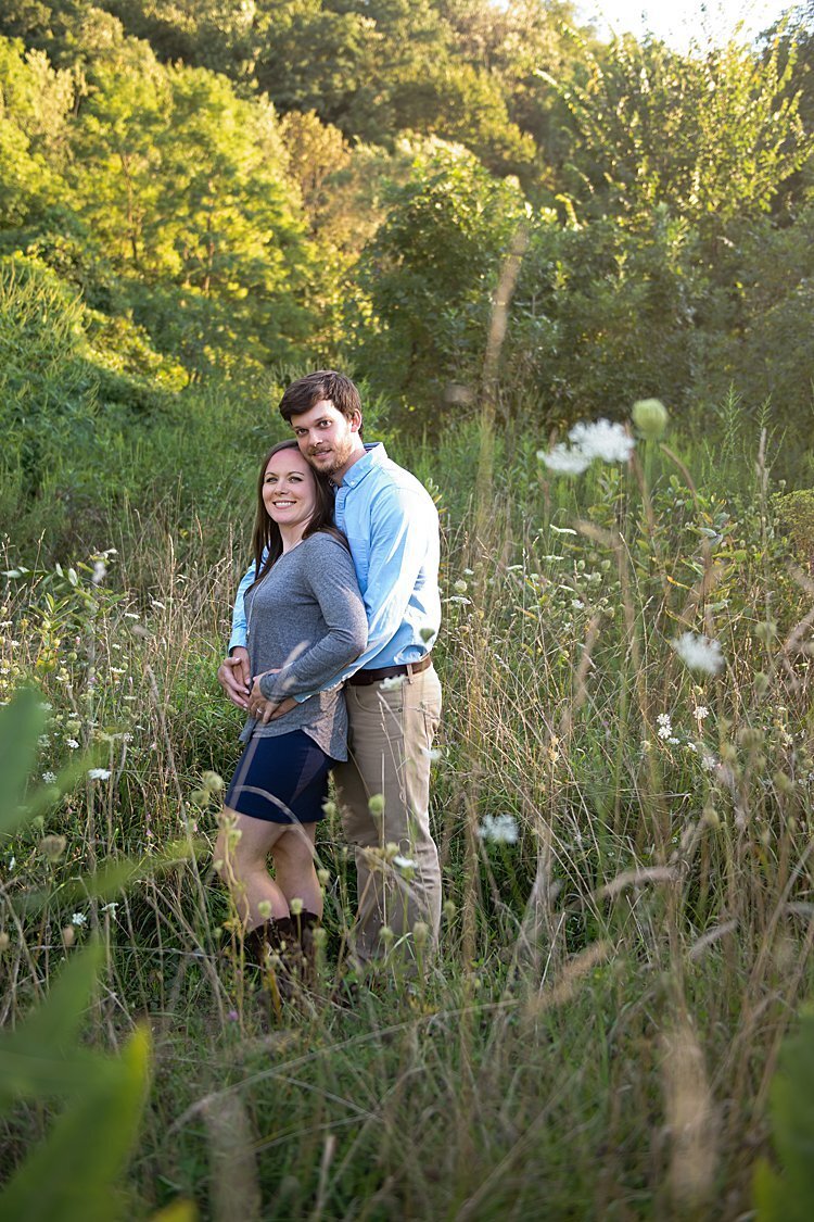 Engaged couple standing in a field of tall grasses during their engagement session in Pittsburgh, PA