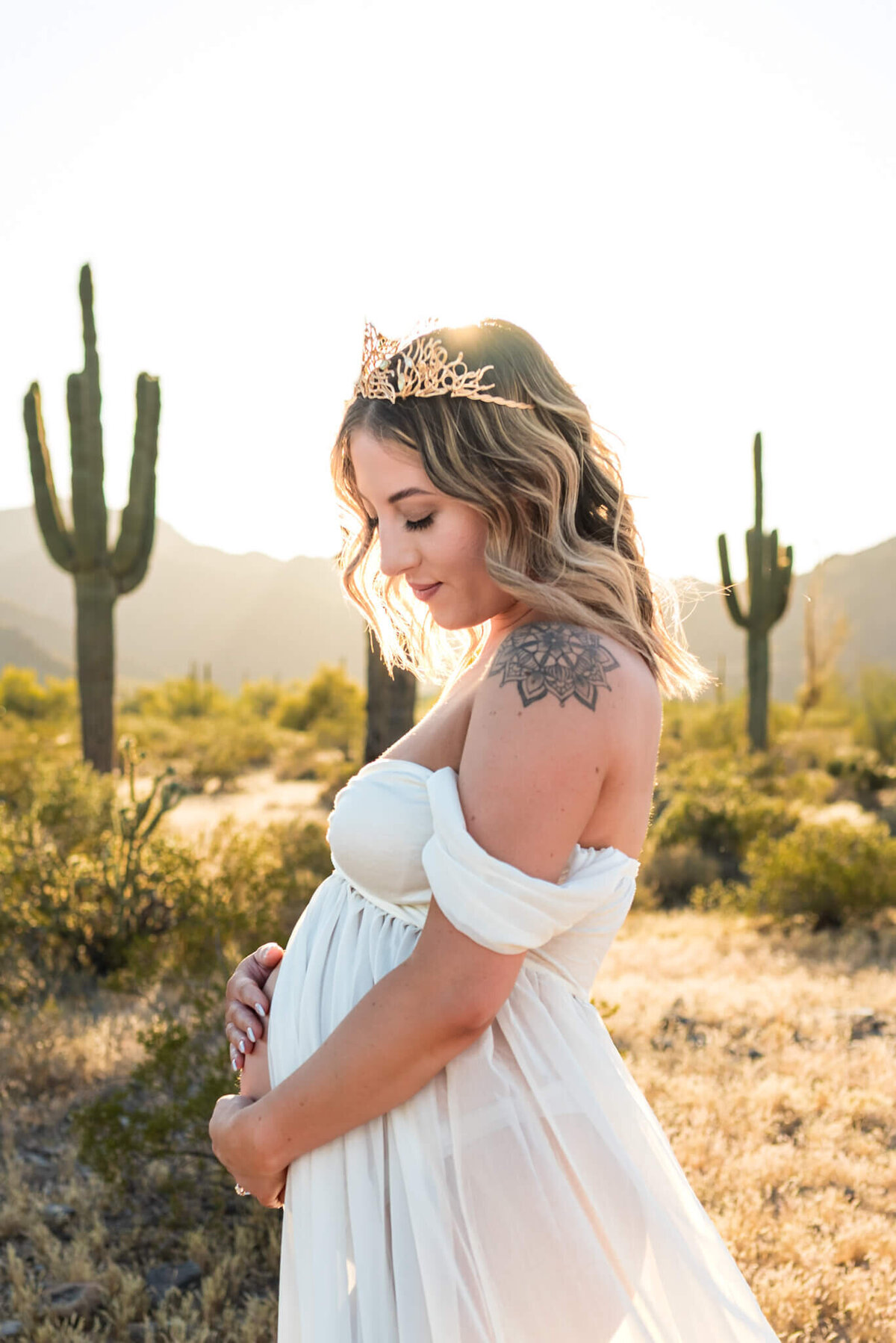 pregnant mom in a crown and white gown for maternity photos in Arizona 