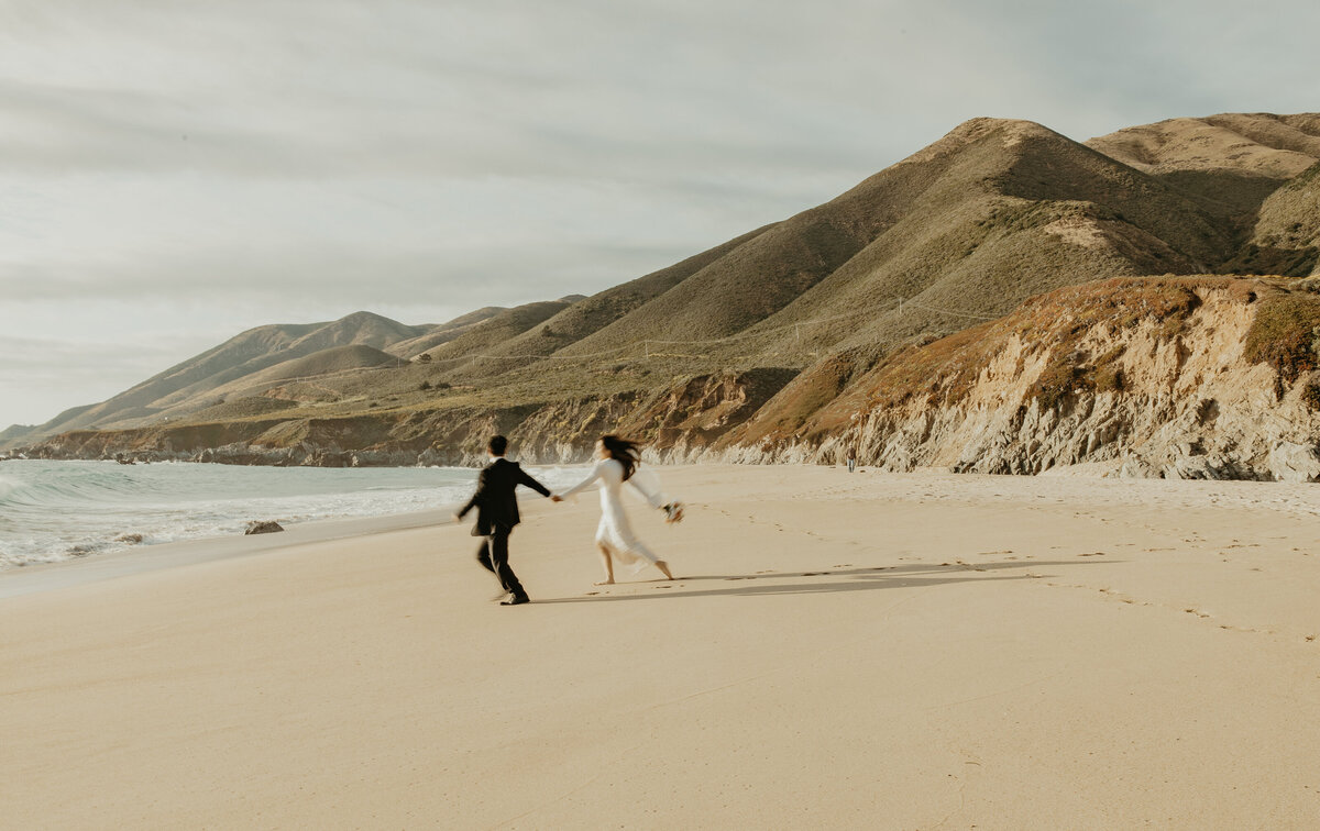 Wedding Photographer & Videographer, bride and groom running on the sand