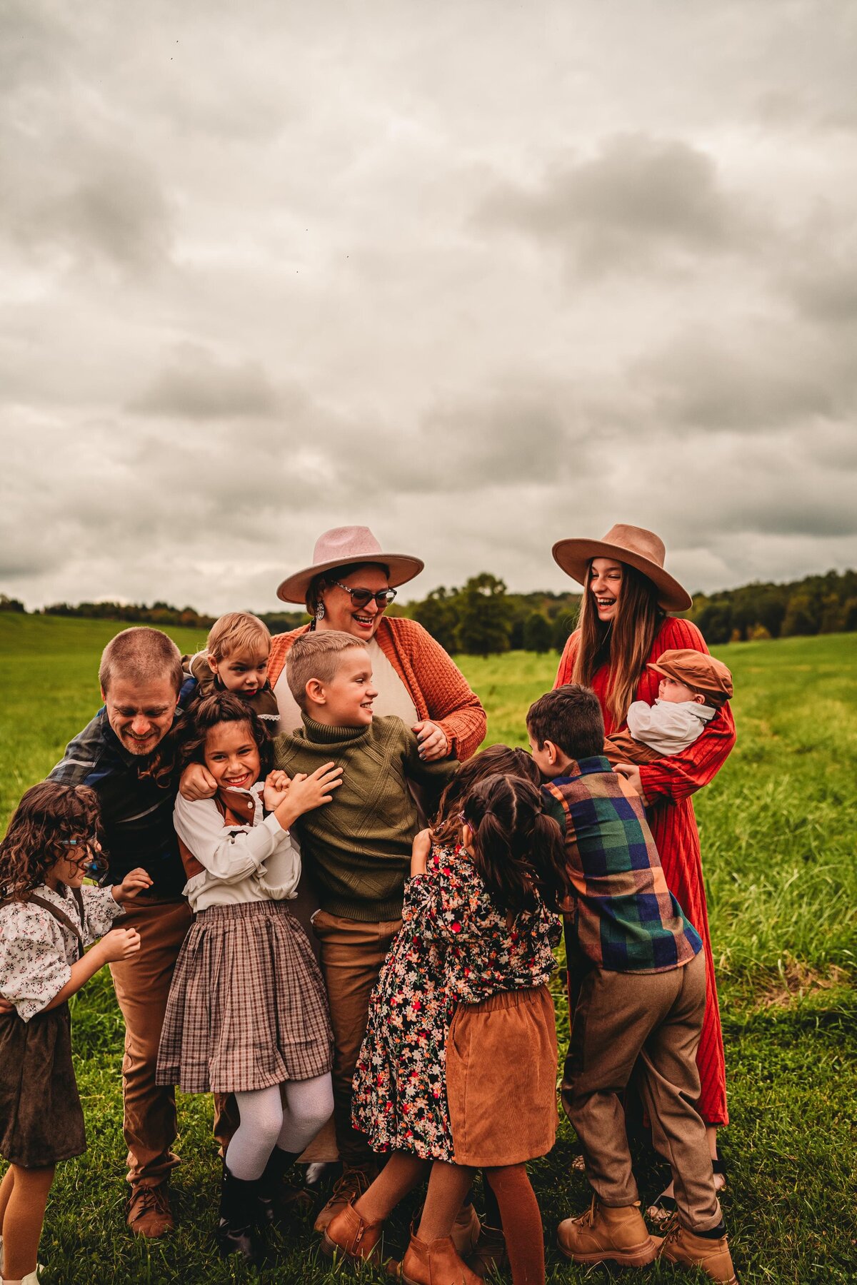 A warm, moody family session in a lush Pittsburgh field, capturing candid joy & connection with earthy tones & authentic emotions.