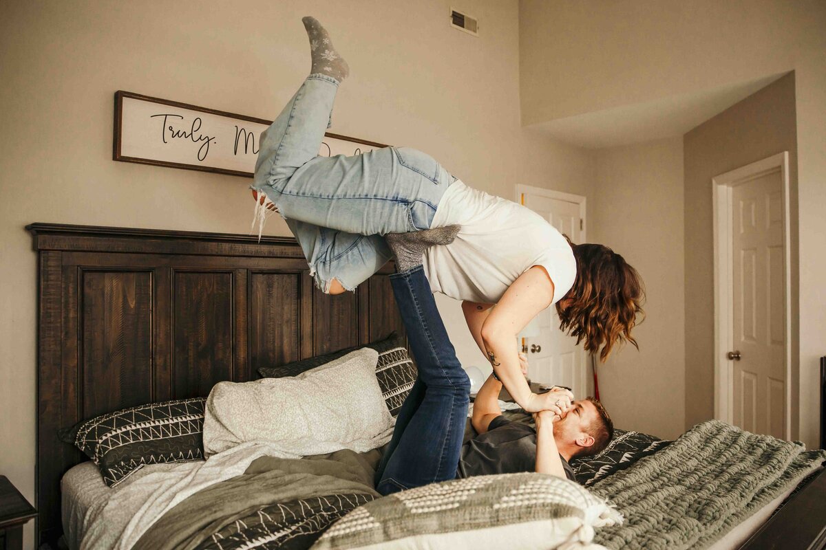 husband holding wife on his feet in bed