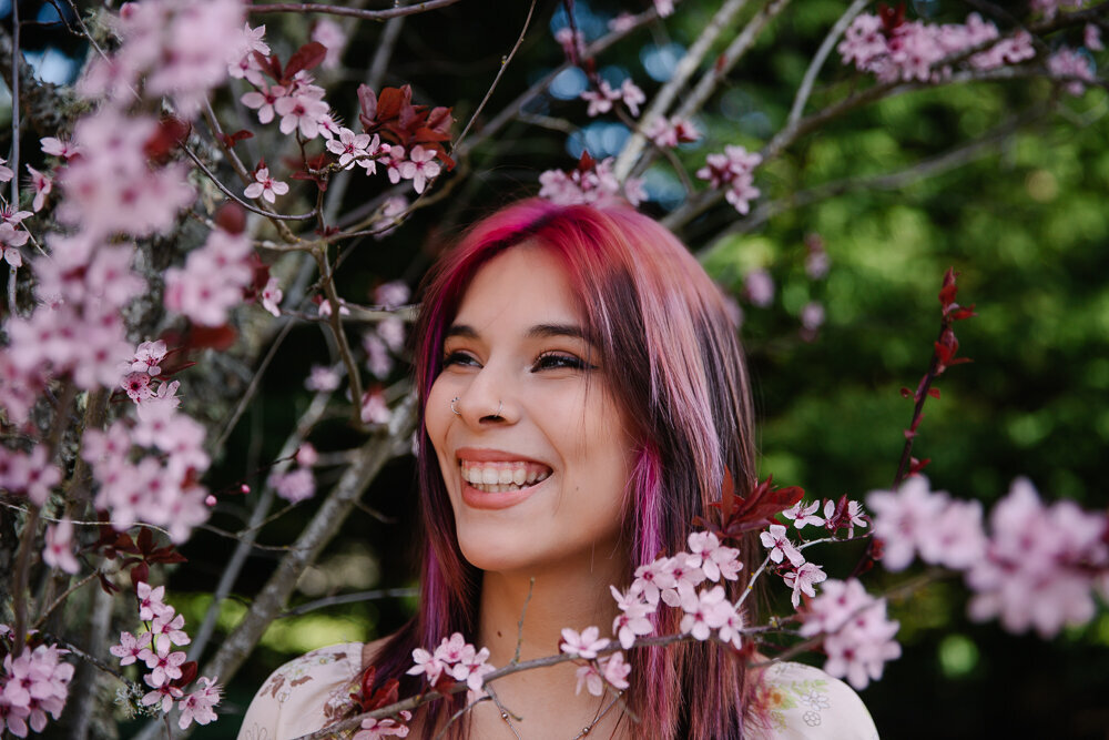Senior girl smiling with cherry blossoms around her